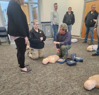 May contain two adults and a child in an indoor setting, discussing something with medical equipment visible.