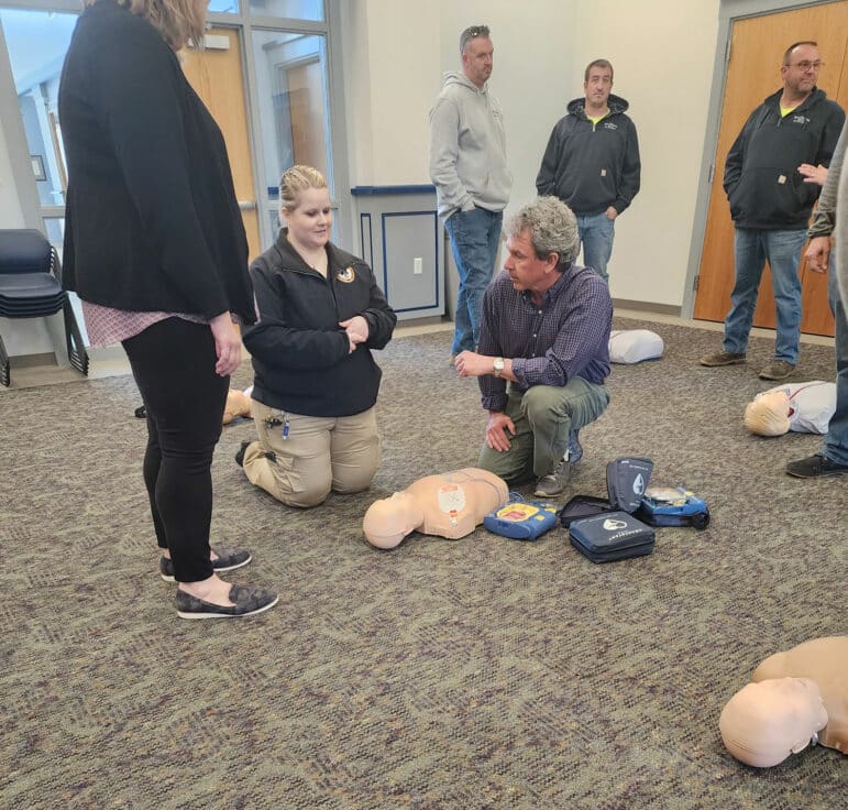 May contain two adults and a child in an indoor setting, discussing something with medical equipment visible.